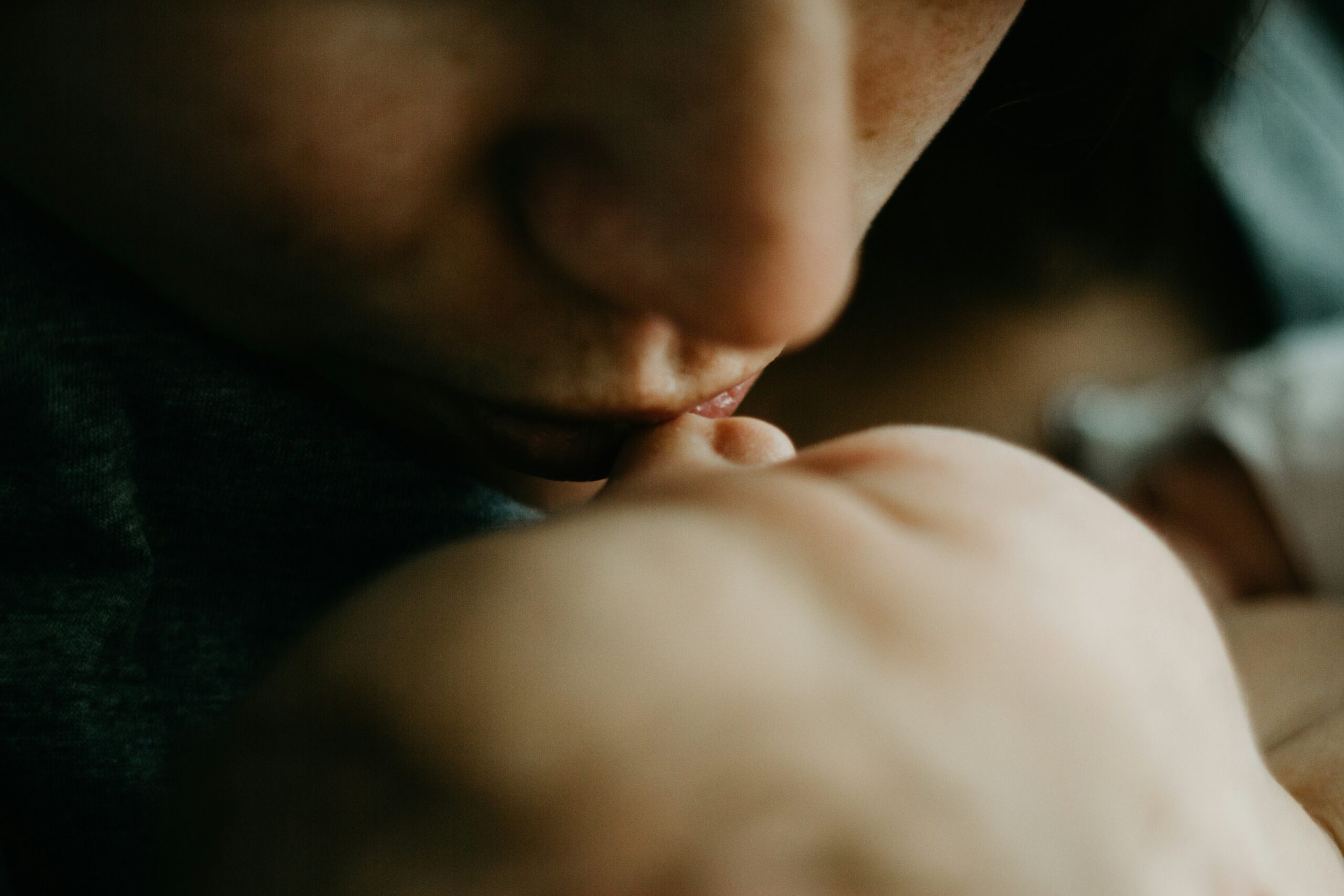 closeup image of a new mom kissing her newborn's nose